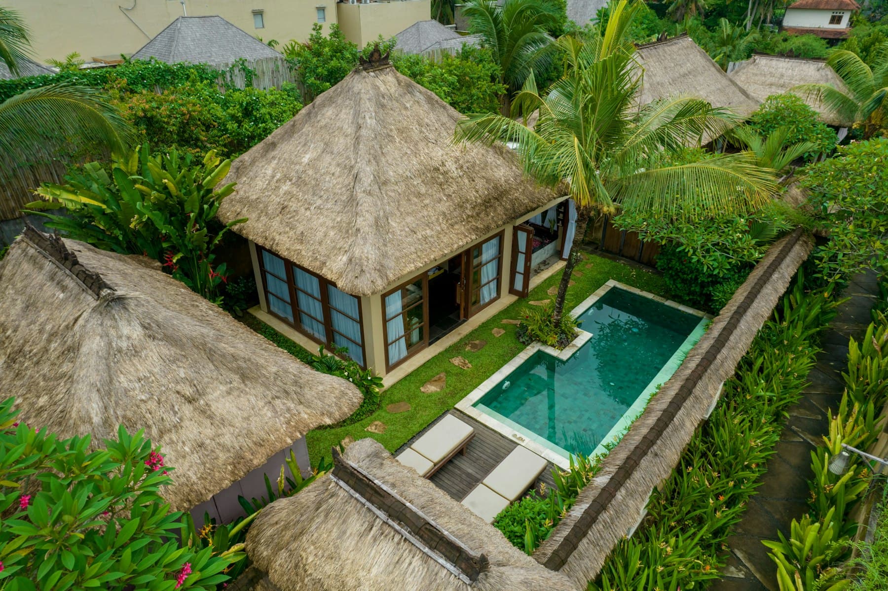 Aerial view of a villa with a private pool in a tropical garden